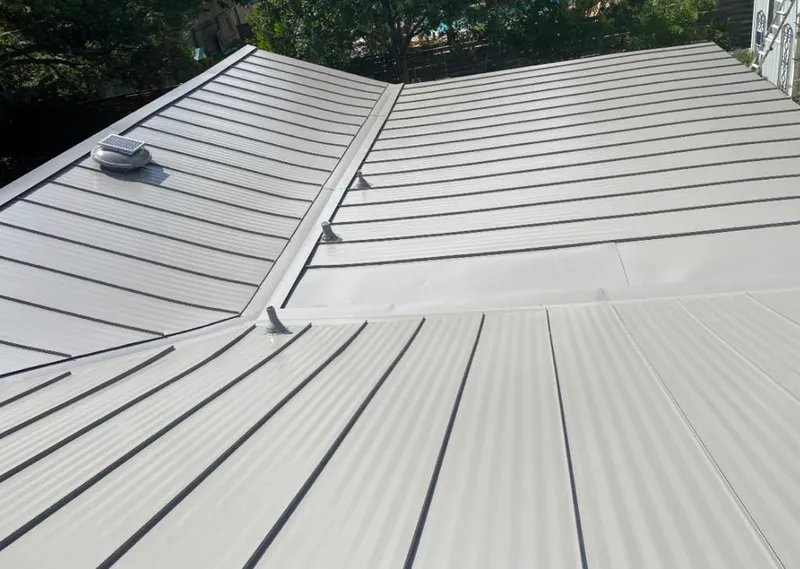 Solar attic fan installed on a metal roof for Roof Ventilation in Brookline